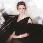 Kvinne som sitter ved et piano